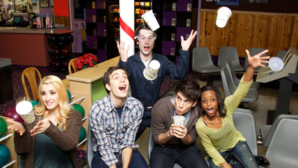 Tim Kubart and the Space Cadets. They are sitting in a bowling alley and cups have been thrown in the air. 