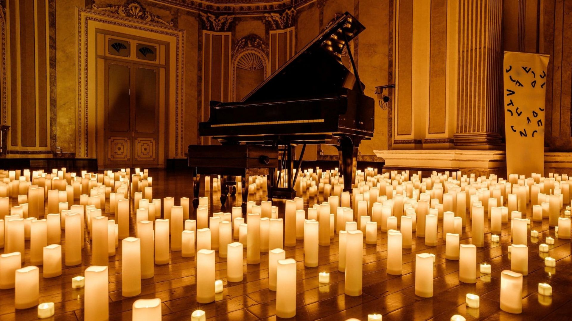 Piano surrounded by hundred of light candles