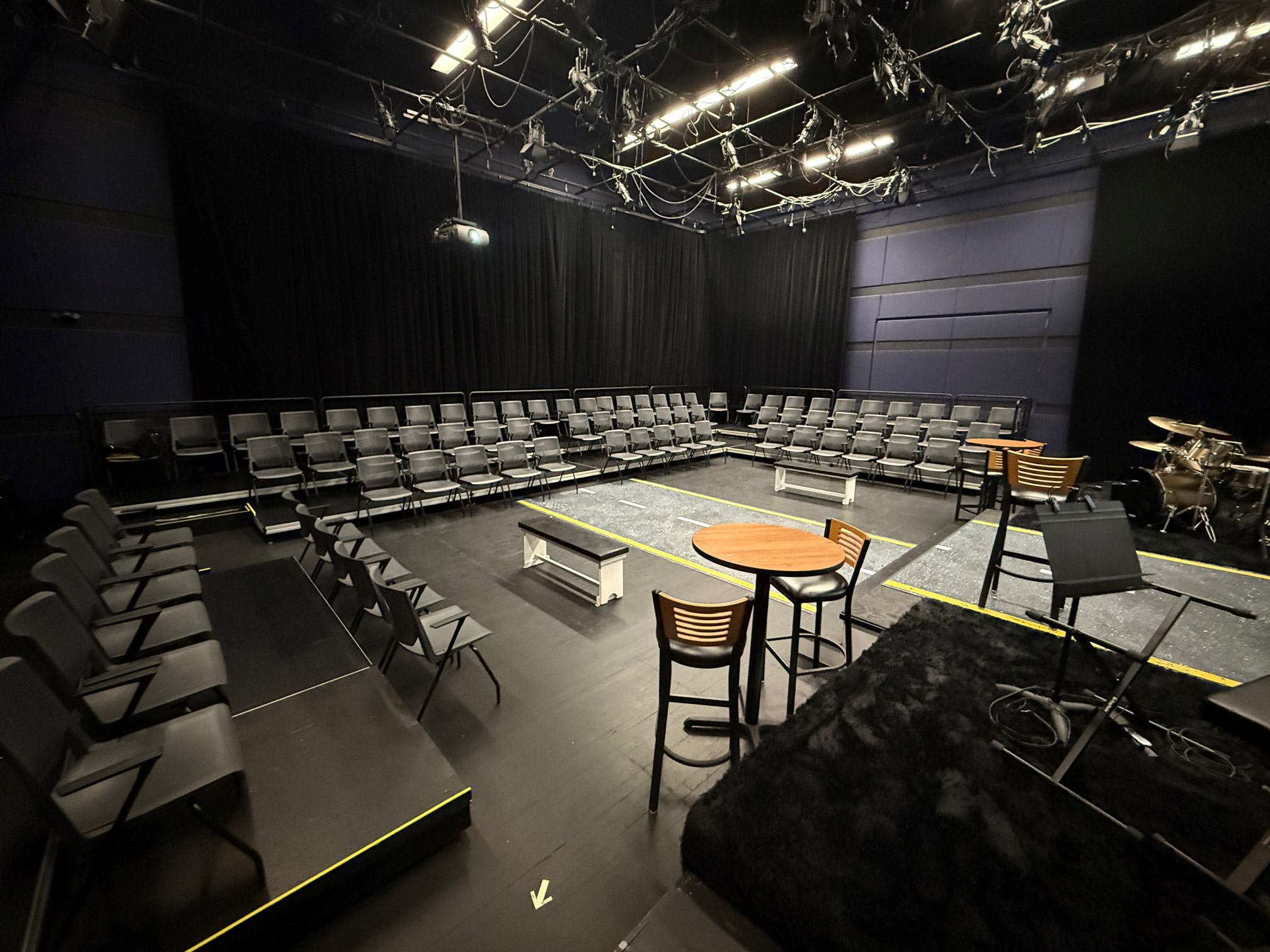 Black-box-2025web Empty black box theater with U-shaped seating and central performance area.