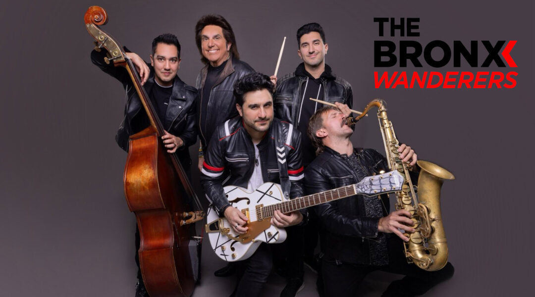 A group of five men in leather jackets pose with musical instruments; a double bass, electric guitar, drumsticks, and a saxophone, against a gray background with "The Bronx Wanderers" text in black and red.