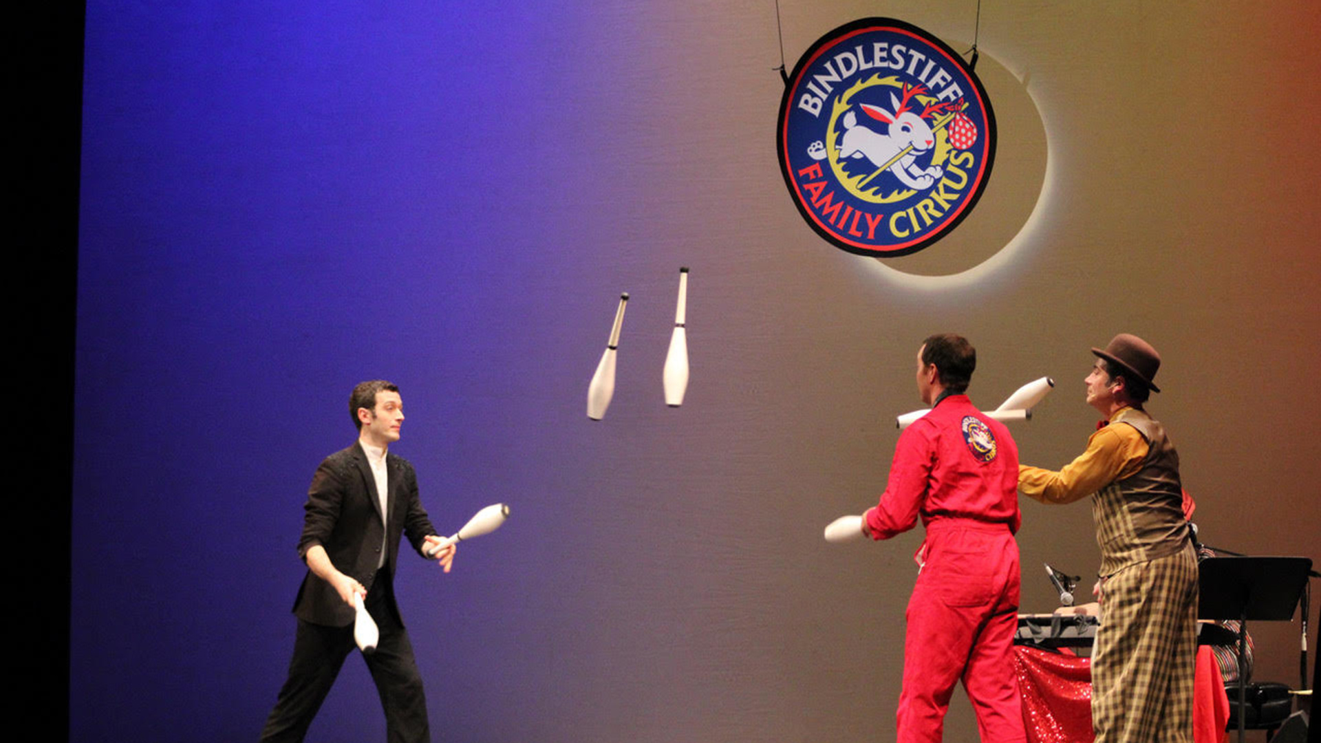 Three jugglers on a stage