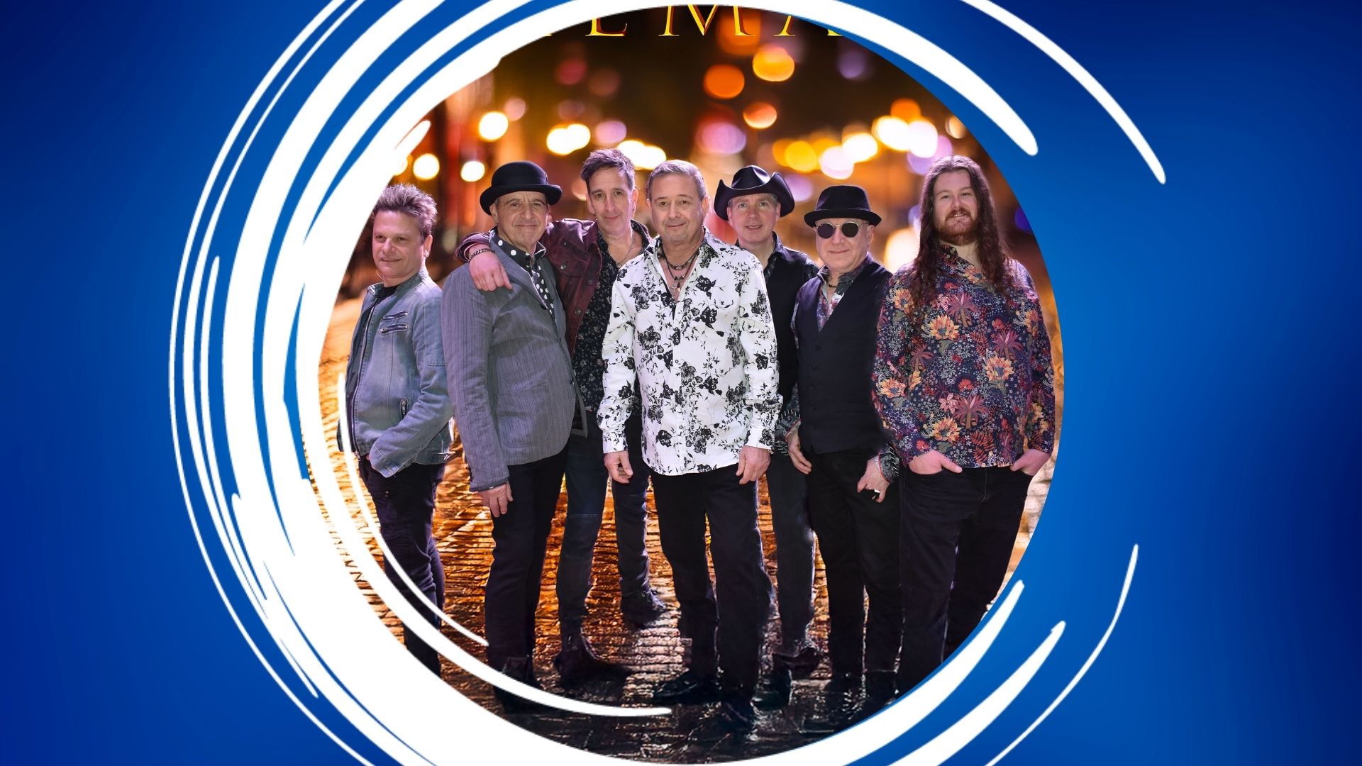EagleMania – 1920×1080 Feature A group of seven men standing together on wet cobblestones, surrounded by abstract blue and white framing against a blurred nighttime cityscape.