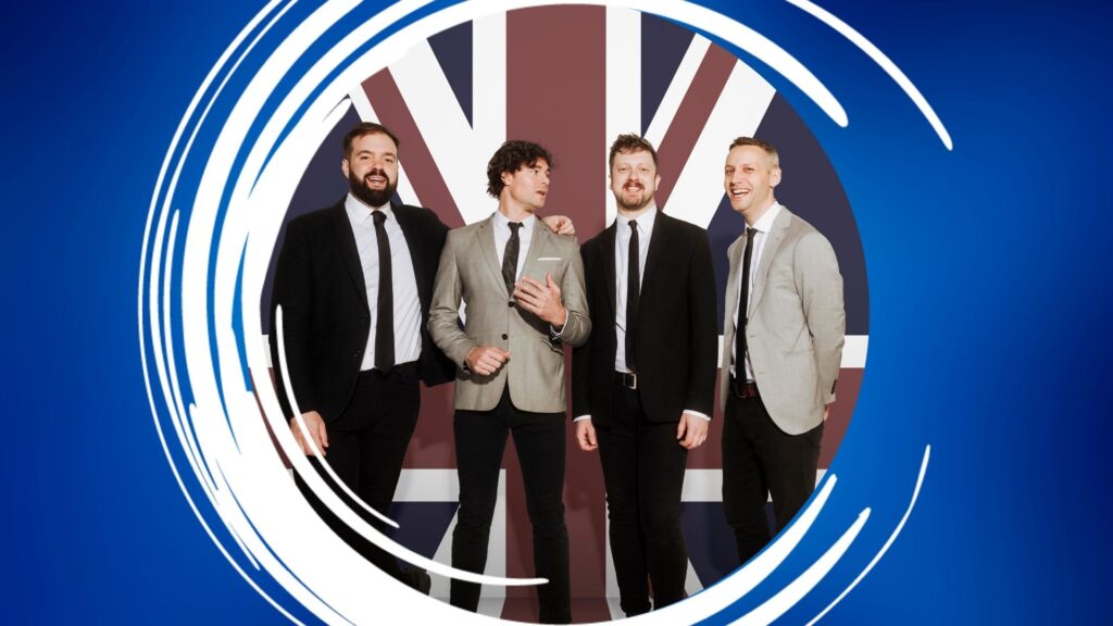 Four men in suits standing in front of a Union Jack background with white brushstrokes over a blue backdrop.