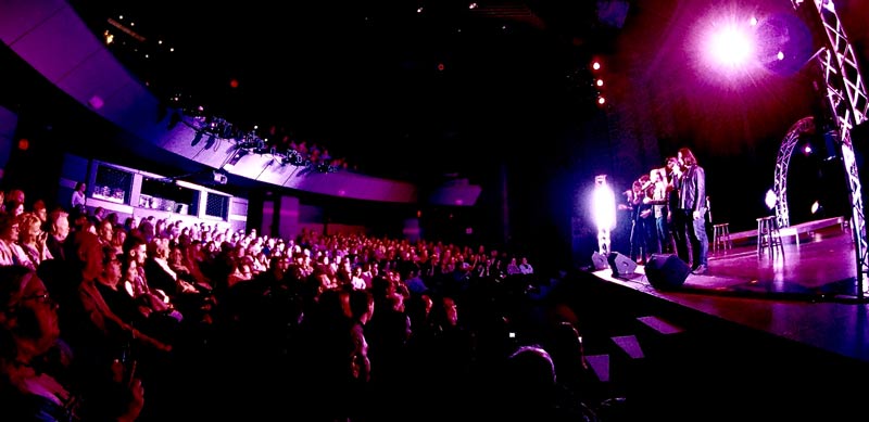 Live performance on stage with large audience seated in theater