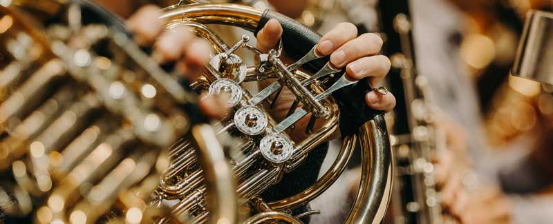 Close up of French Horns and other symphonic instruments being played