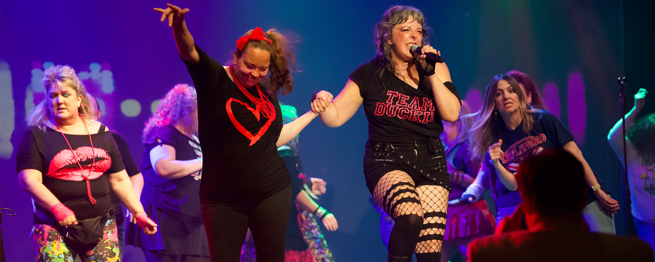 Performers on stage in 80s-themed costumes