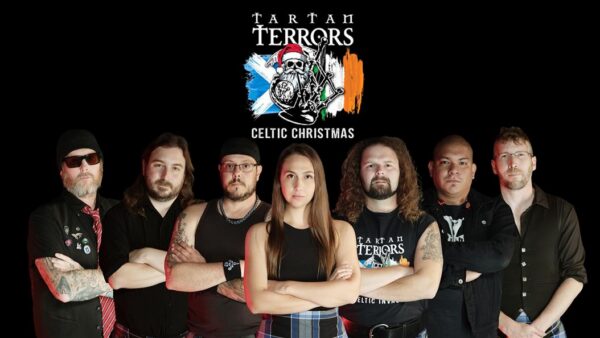 Seven band members of the Tartan Terrors pose in front of a logo with a Celtic theme.