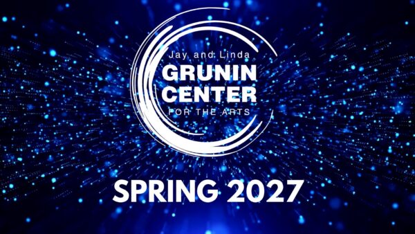 Promotional graphic for the Jay and Linda Grunin Center for the Arts announcing “Spring 2027,” set against a glowing blue particle background.